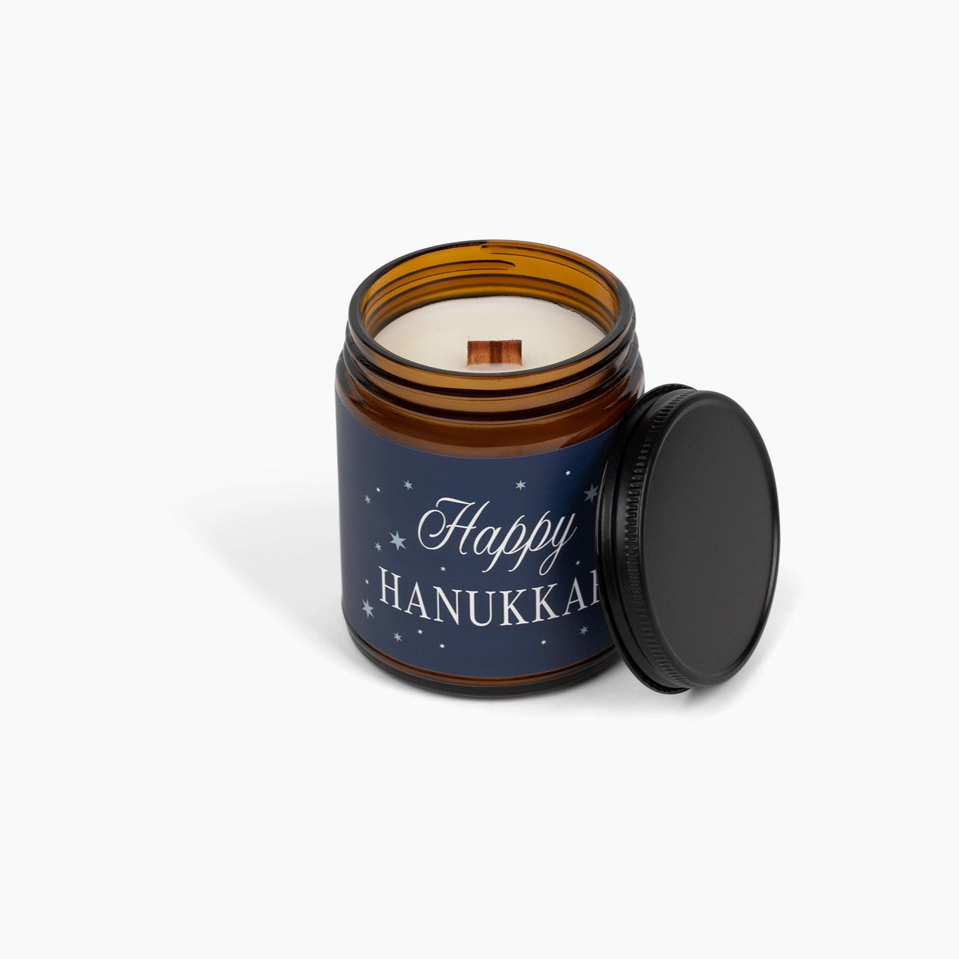 Candle in an amber jar with a 'Happy Hanukkah' label on a white background