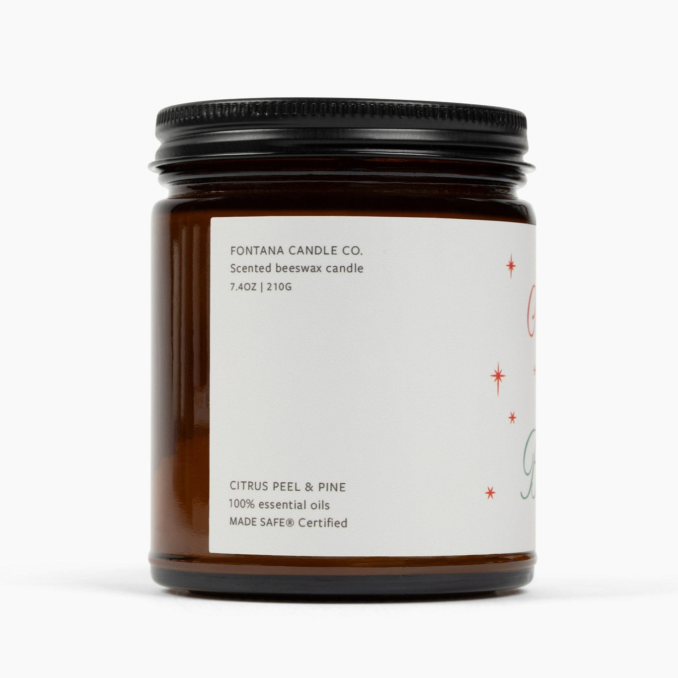 Unlit amber glass jar candle from the side with a cream colored label, showing the scent: Citrus Peel and Pine.
