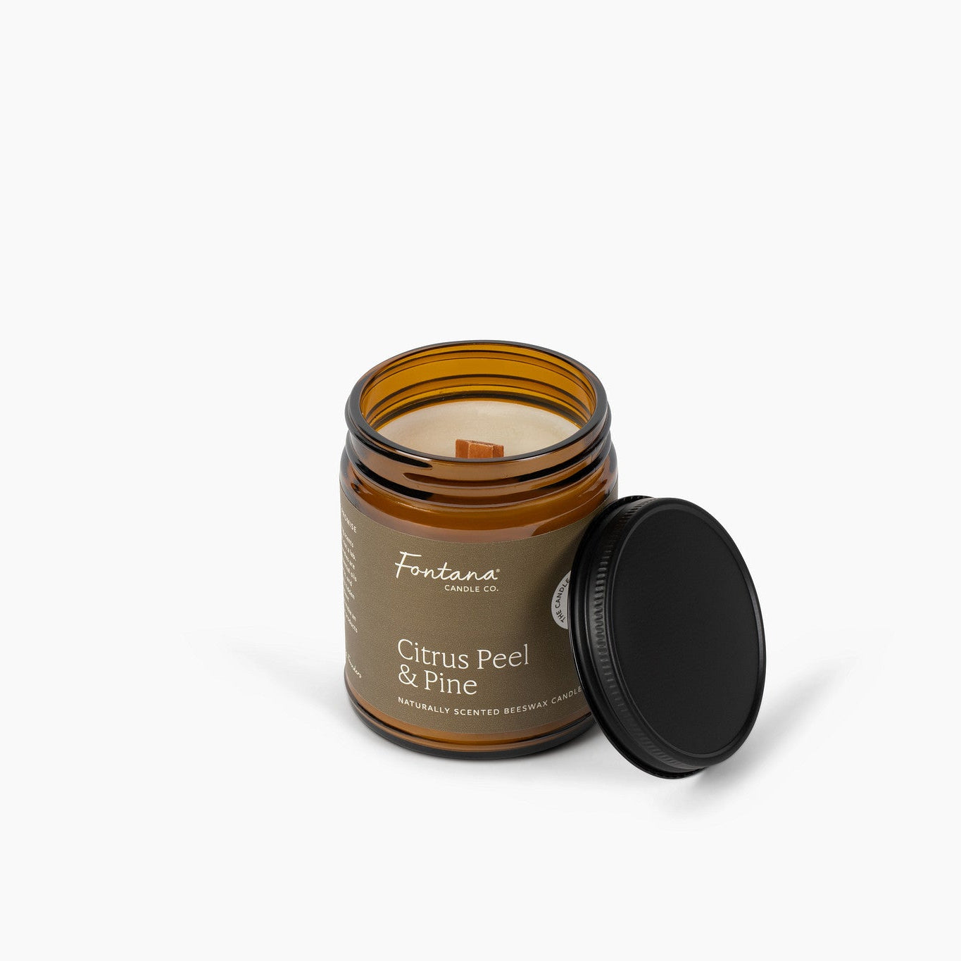 Scented candle in an amber jar with a black lid on a white background