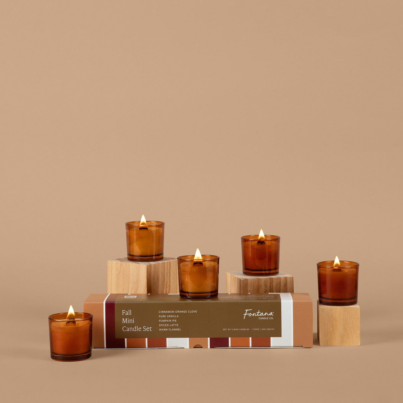 A set of amber glass candles and a closed box labeled 'Full Set Candle Set' with the brand 'Fondana', arranged on small wooden blocks against a solid beige background.