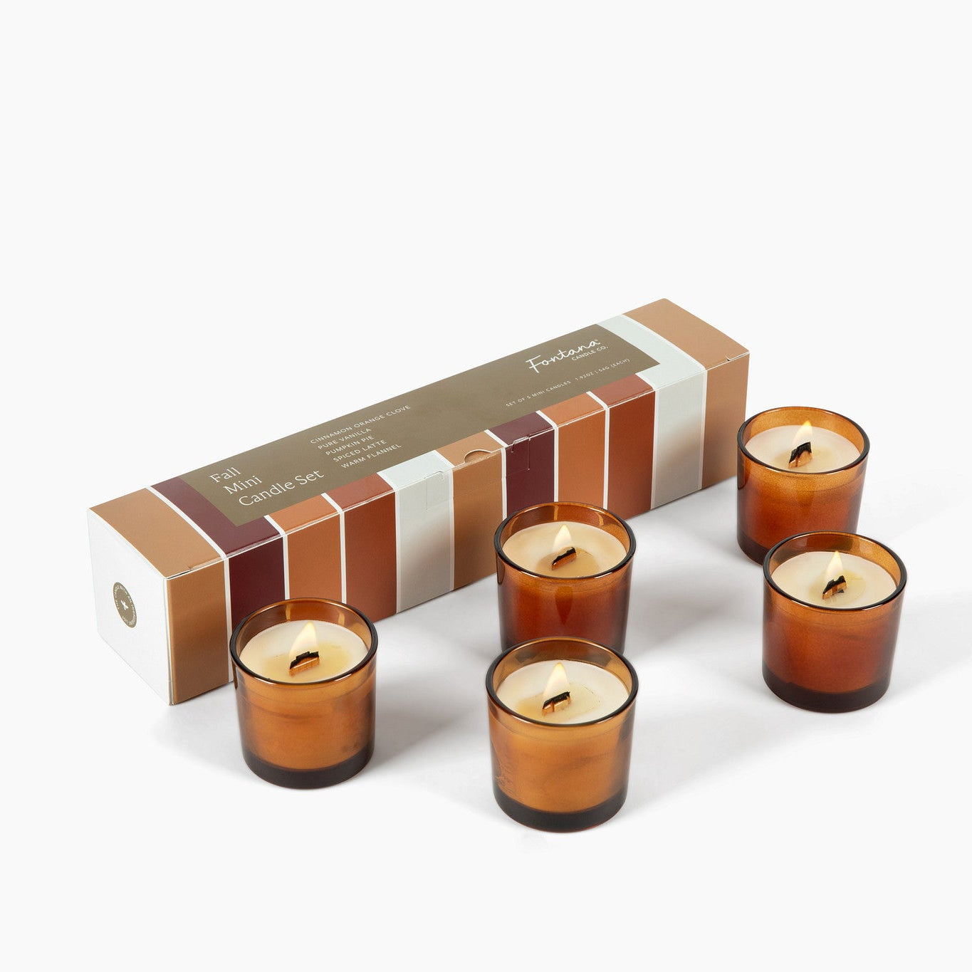 Five amber glass candle holders with lit candles arranged in front of a rectangular product box on a clean white background.