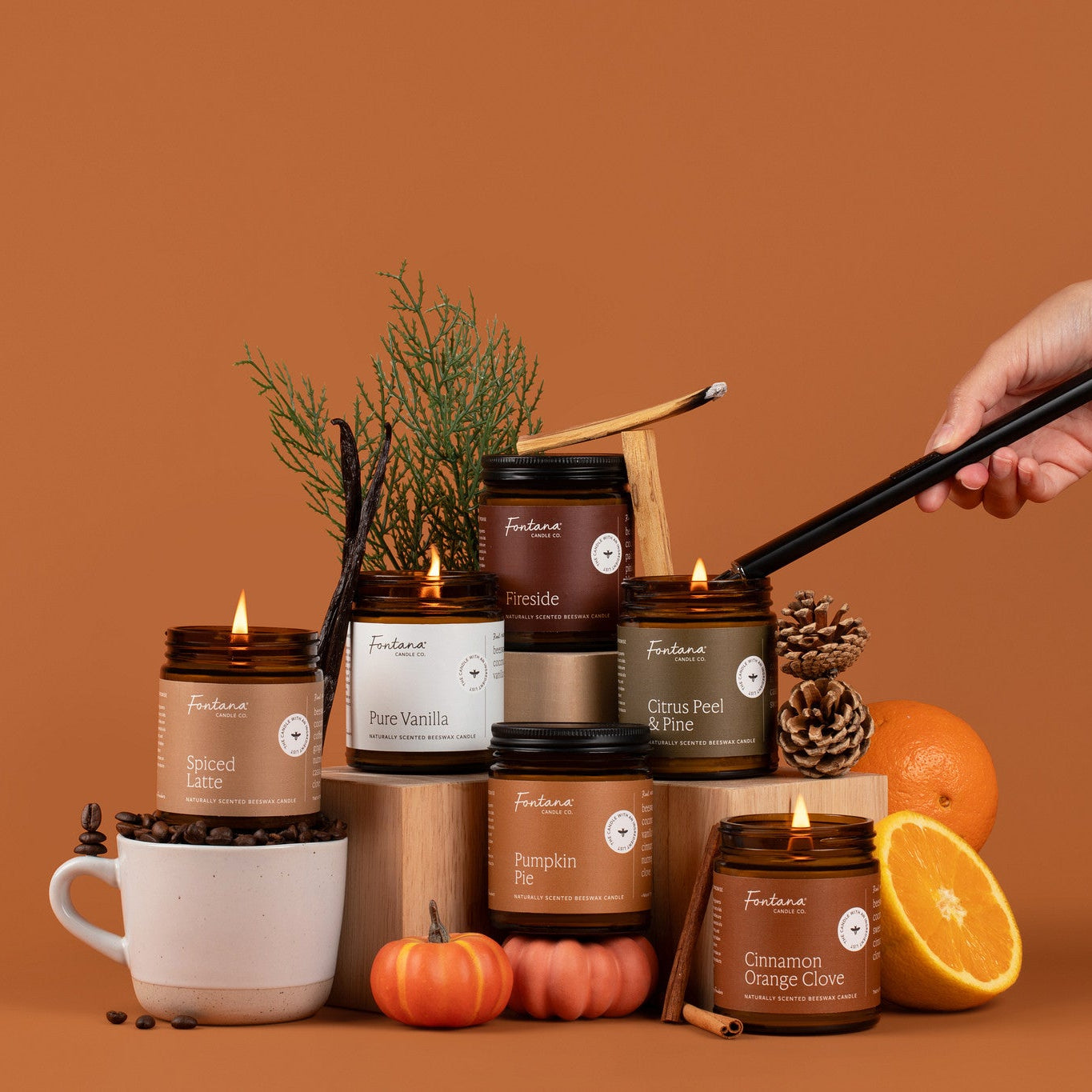 Collection of candles with decorative items on an orange background