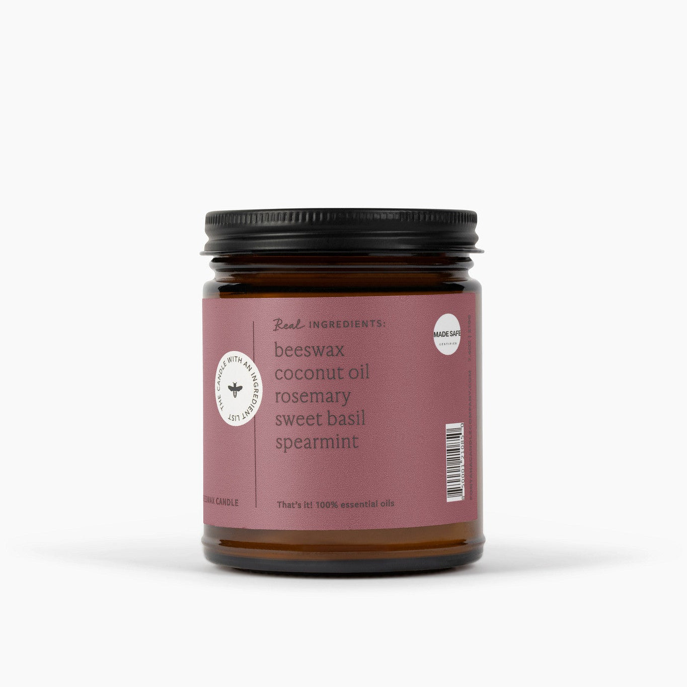side view of an Amber glass jar candle with a pink label on a white background.