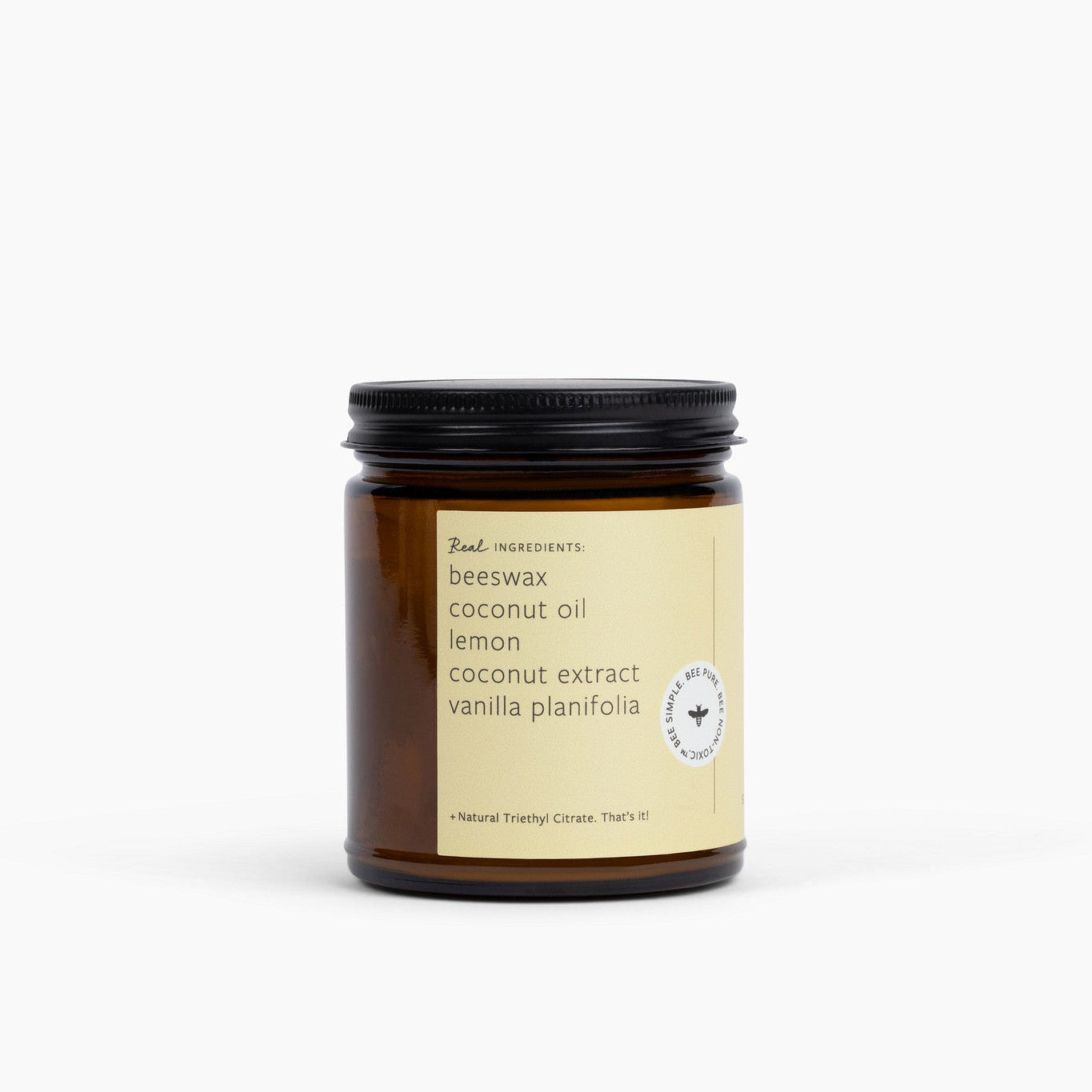 Side view of amber glass jar candle with a yellow label on a white background.