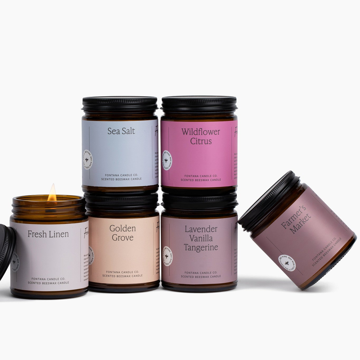 Set of 6 amber jar candles with colorful labels on a white background.