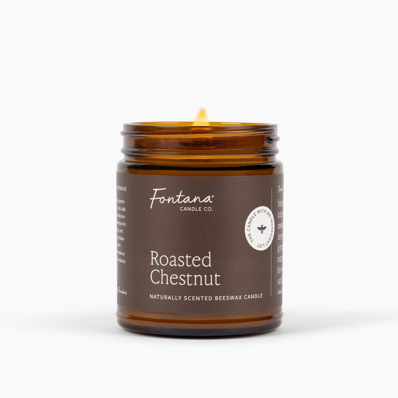An amber glass jar candle with a lit wick, featuring a dark brown label that reads 'Fontana Candle Co. Roasted Chestnut' on a clean white background.