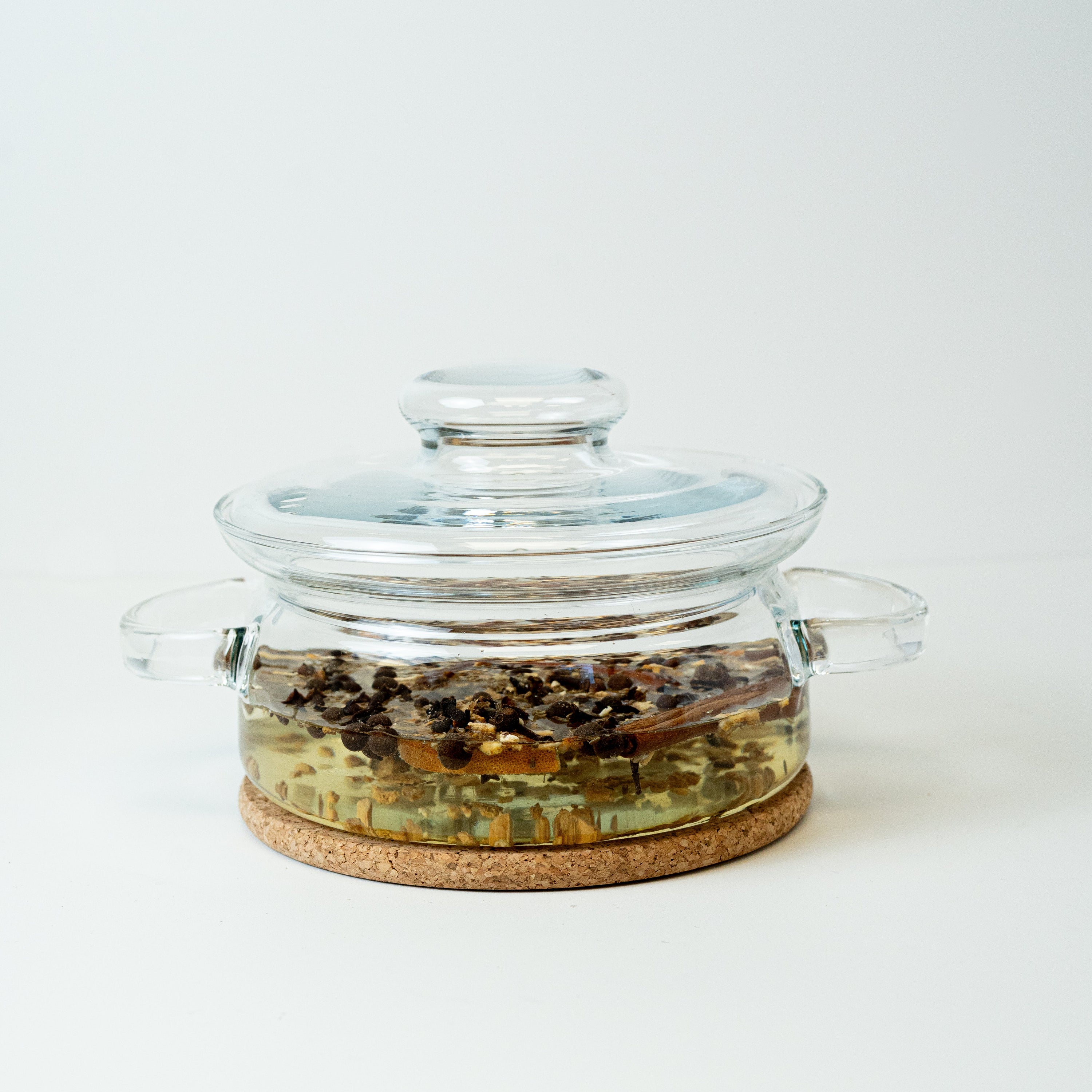 Glass jar with cork base on a white background