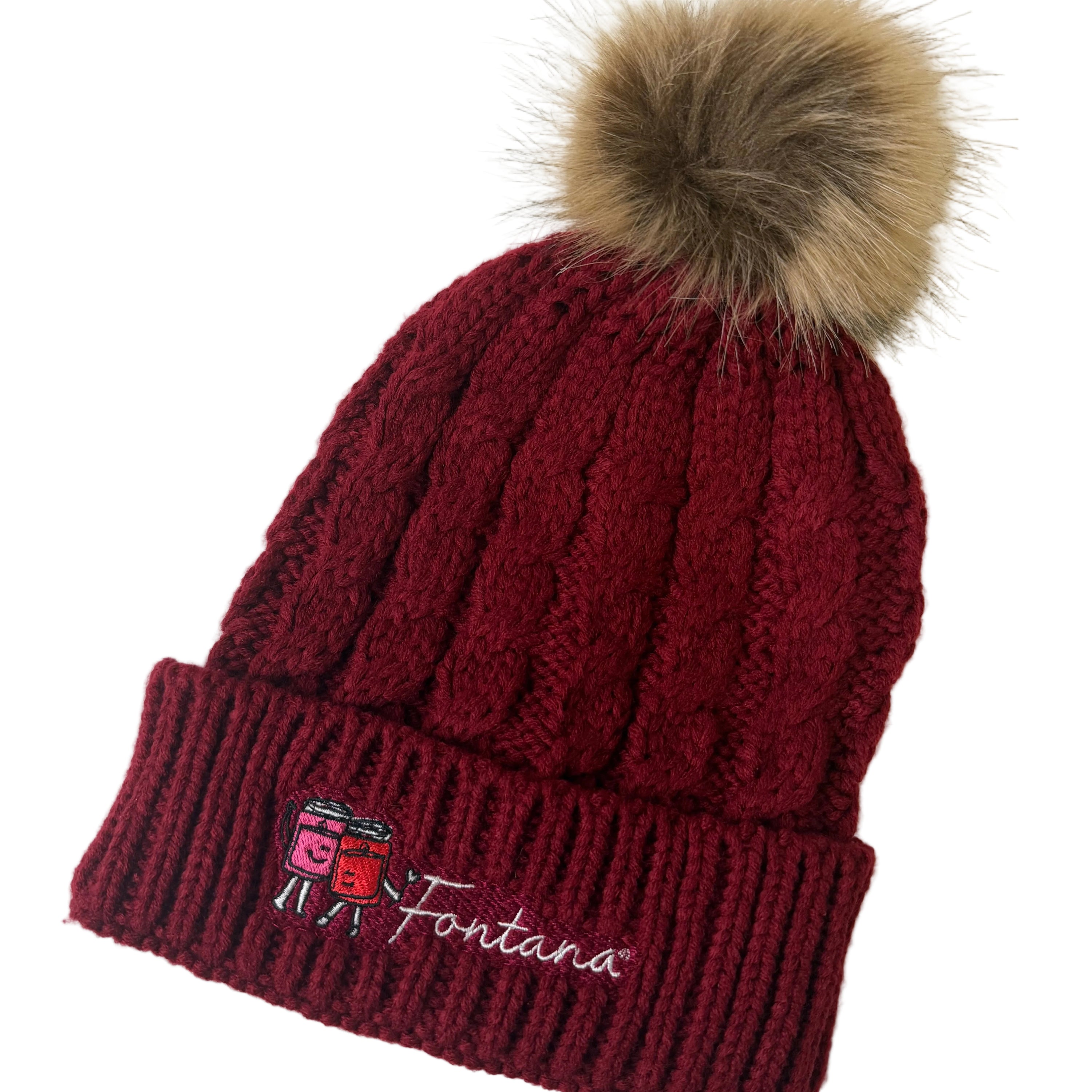 Maroon knit beanie with fur pom-pom and embroidered logo on a light background