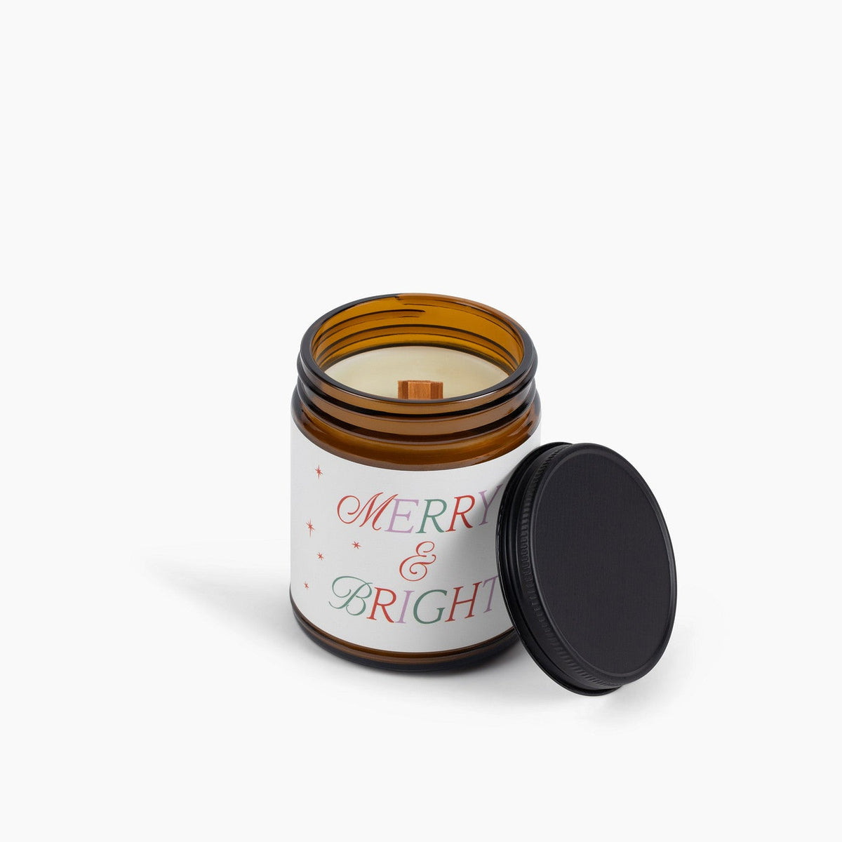 Candle in a jar with 'Merry &amp; Bright' label on a white background