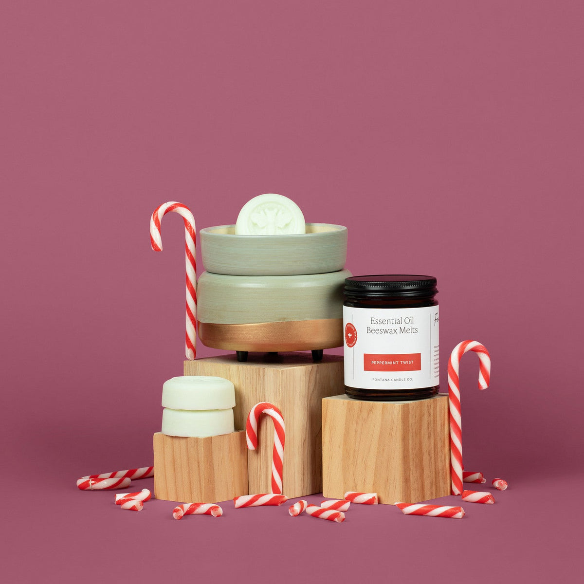Peppermint Twist wax melts and wax melter surrounded by candy canes on a purple background.
