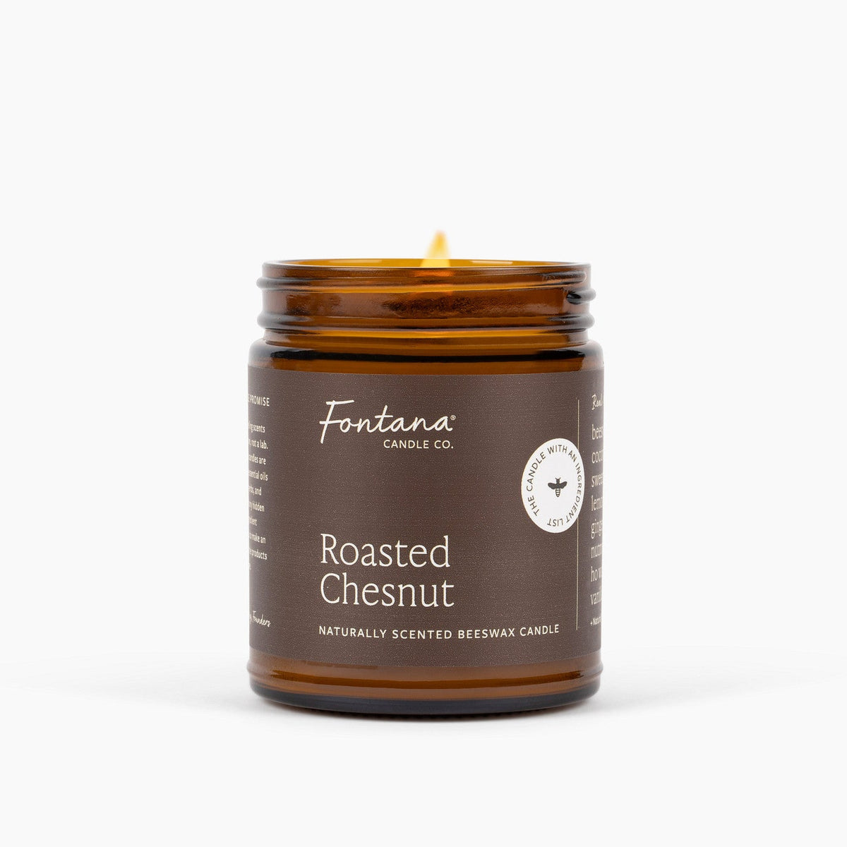 An amber glass jar candle with a lit wick, featuring a dark brown label that reads 'Fontana Candle Co. Roasted Chesnut' on a clean white background.