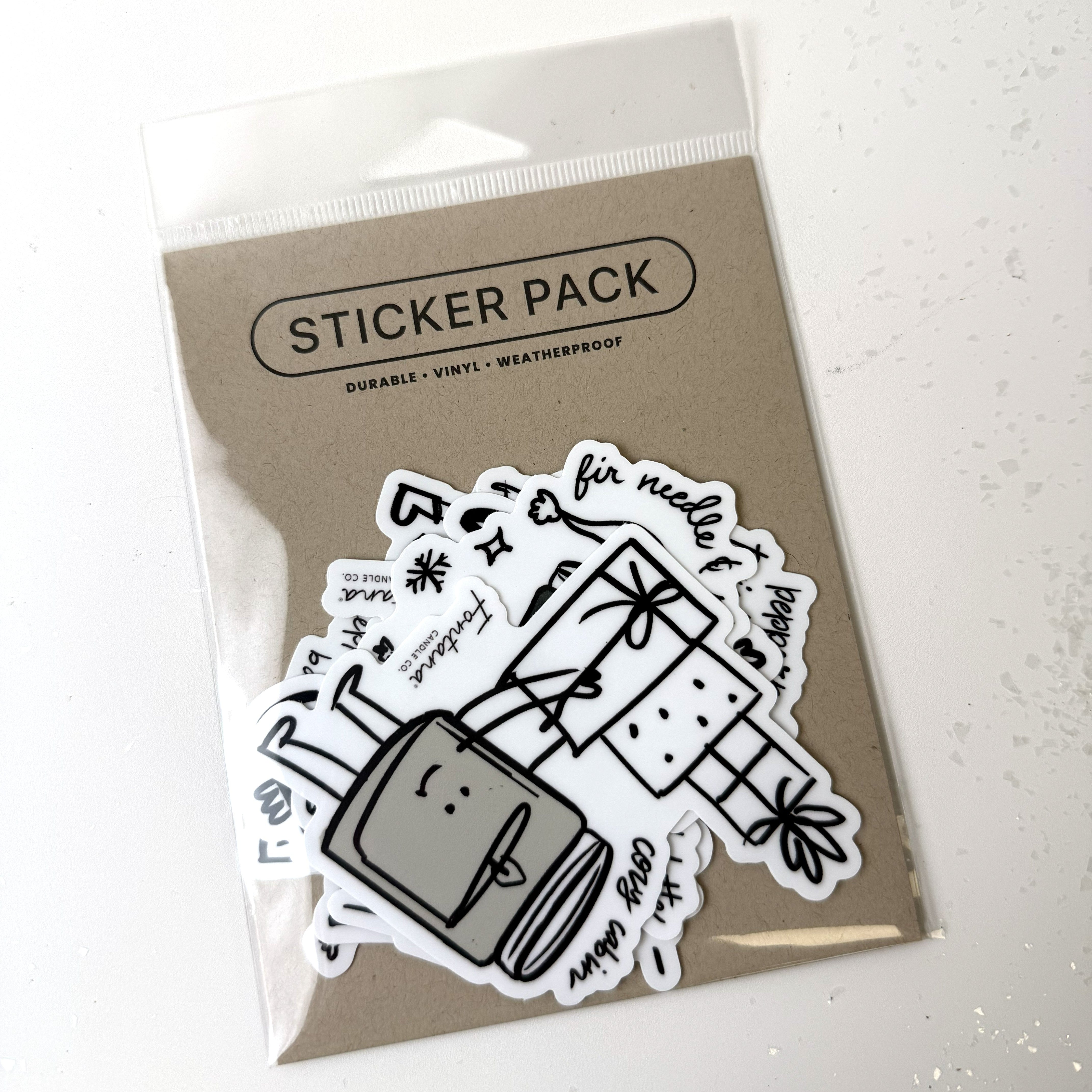 Sticker pack with black and white holiday candle designs on a clear plastic sheet against a white background