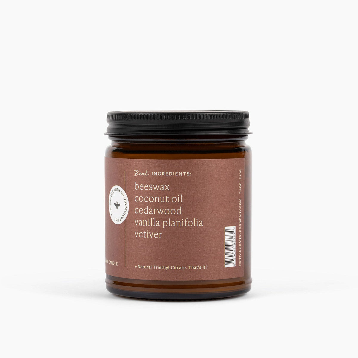 Amber glass jar candle jar with an ingredient label on the side listing beeswax, coconut oil, cedarwood, vanilla planifolia and vetiver on a white background
