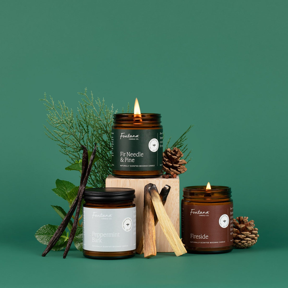 Collection of candles with natural elements on a green background
