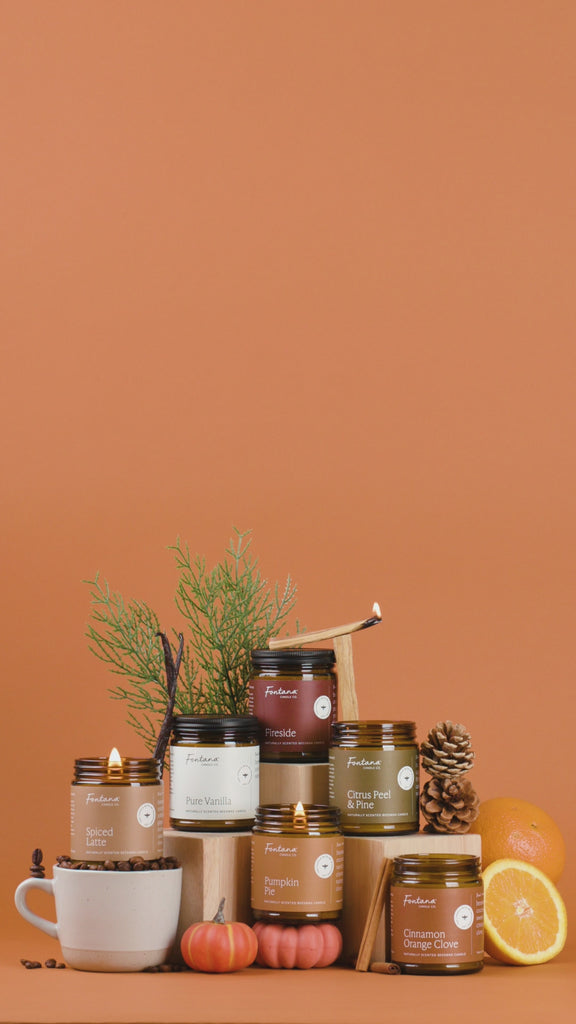 Collection of candles with decorative items on an orange background