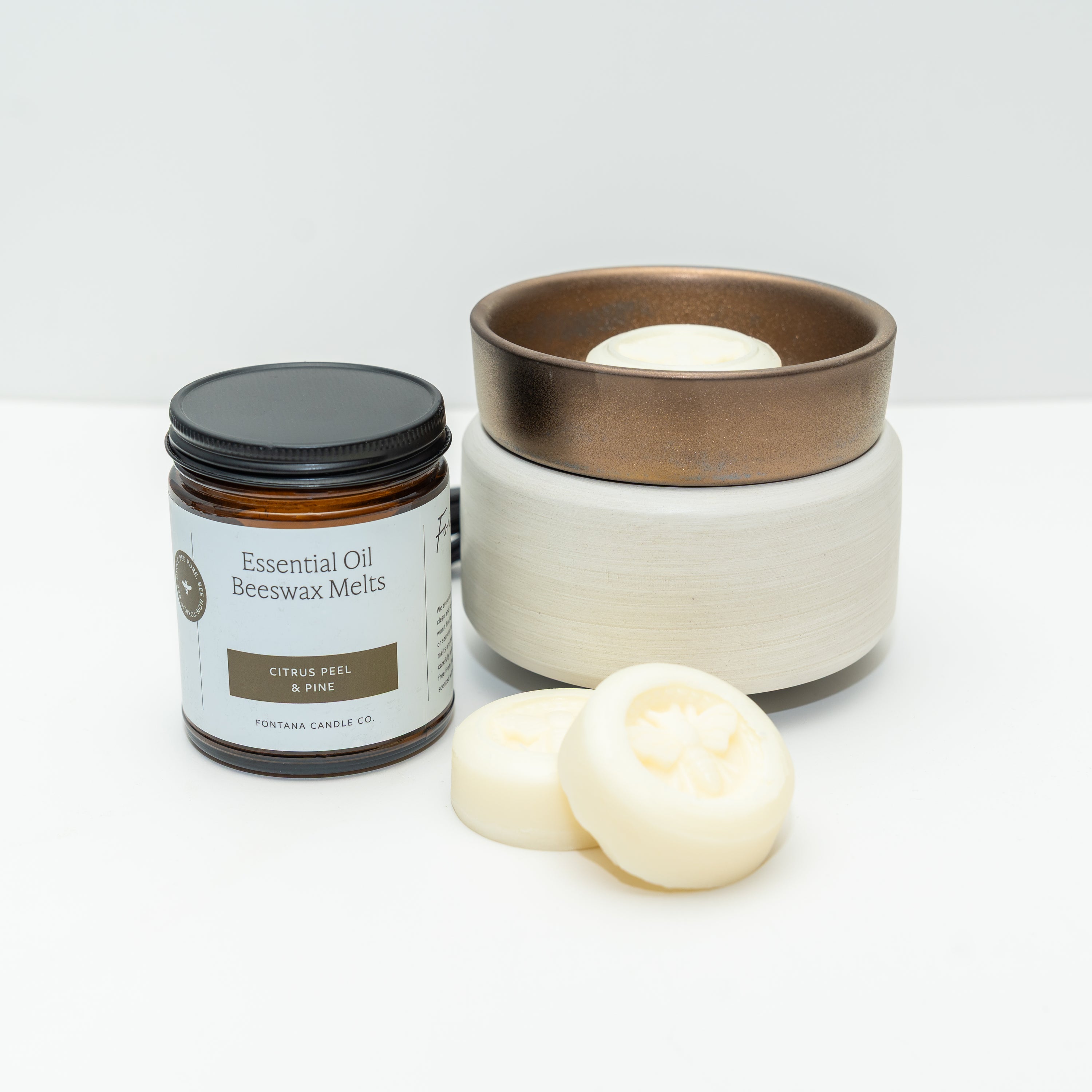 Ceramic wax warmer with a white bottom and bronze top. The picture also shows a jar of Fontana Wax Melts, on a white background.