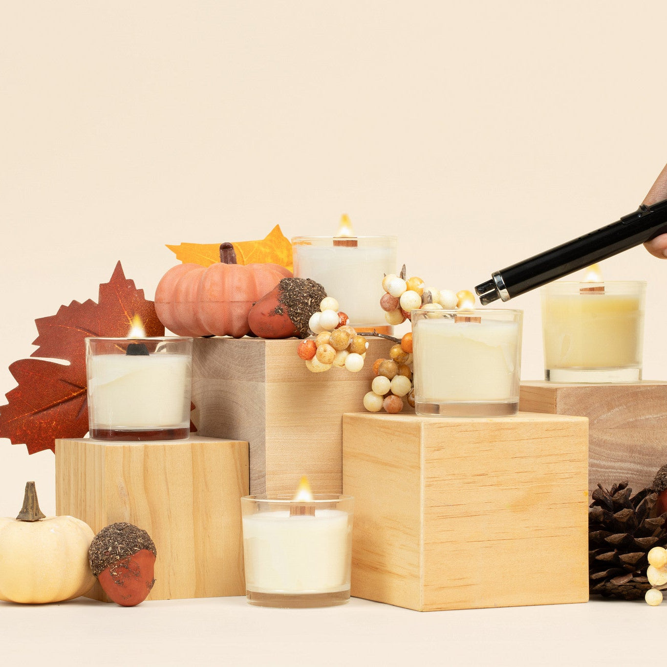 5 Lit mini glass candles surrounded by fall leaves, pumpkins, acorns and pinecones. 