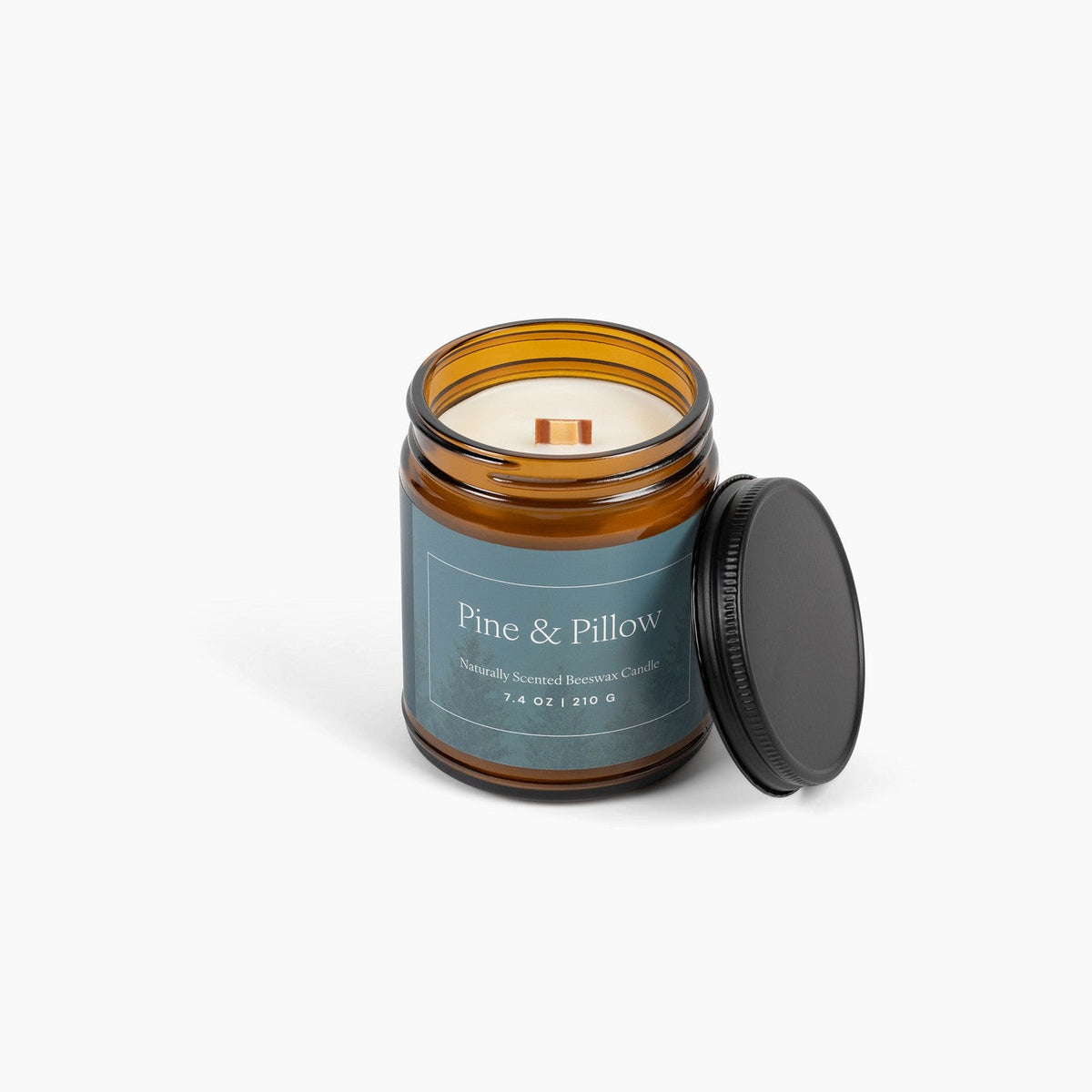 Amber glass jar candle with a wooden wick, in front of a white background.
