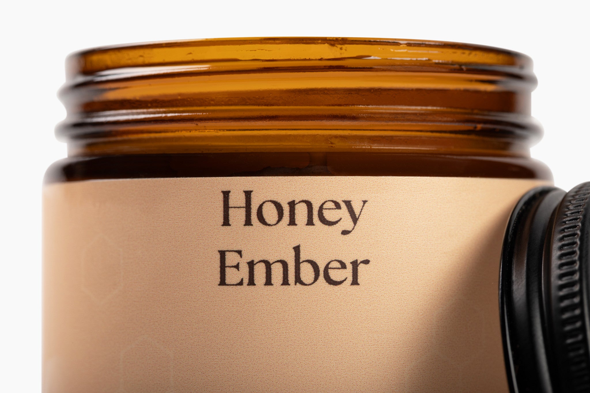 Honey ember jar candle with a beige label on a white background