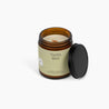 Unlit amber glass jar candle with a light green label, and Vanilla Mint on the front. Candle is in front of a white background.