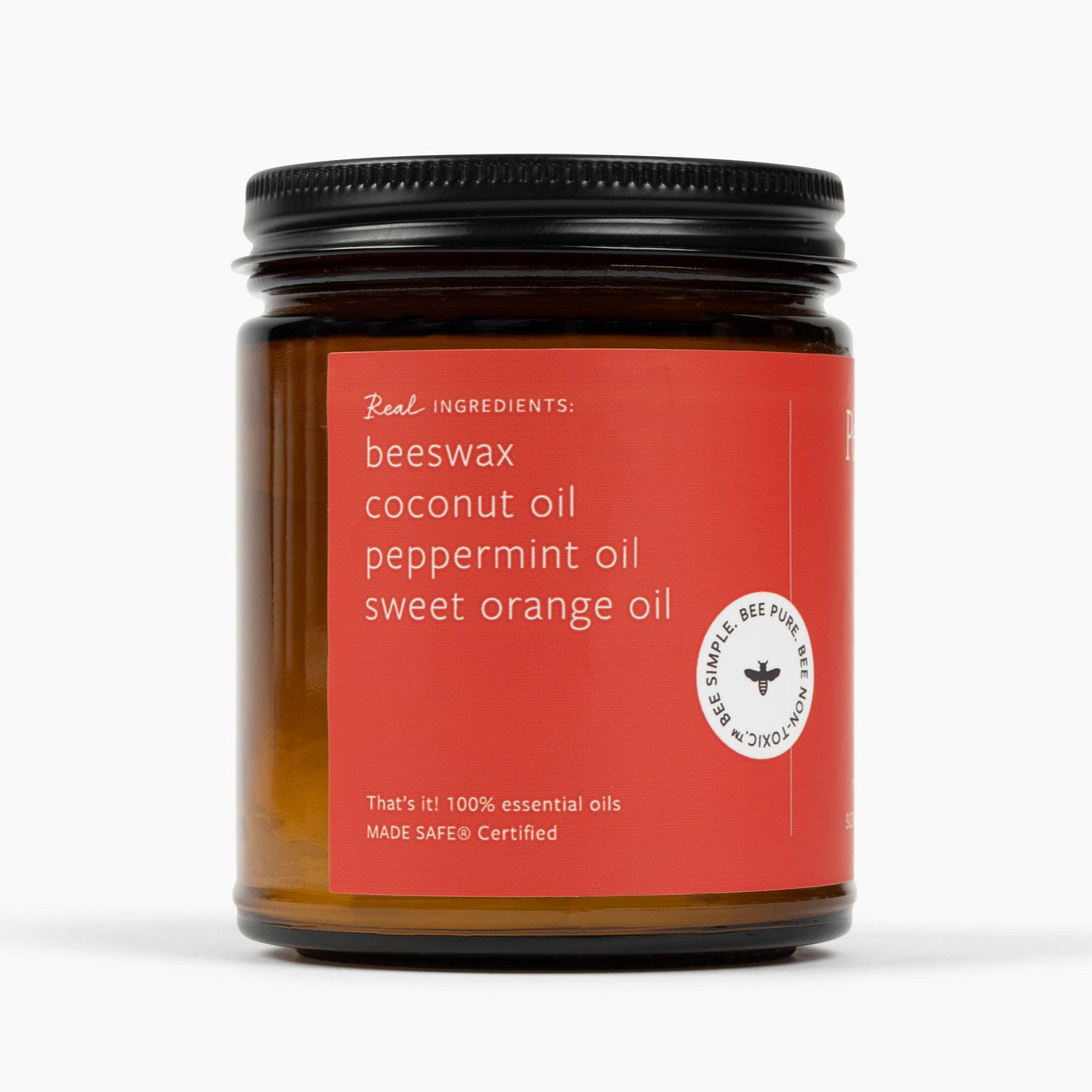 Side view of amber glass jar candle with a red label and ingredients: beeswax, coconut oil, peppermint oil, sweet orange oil.