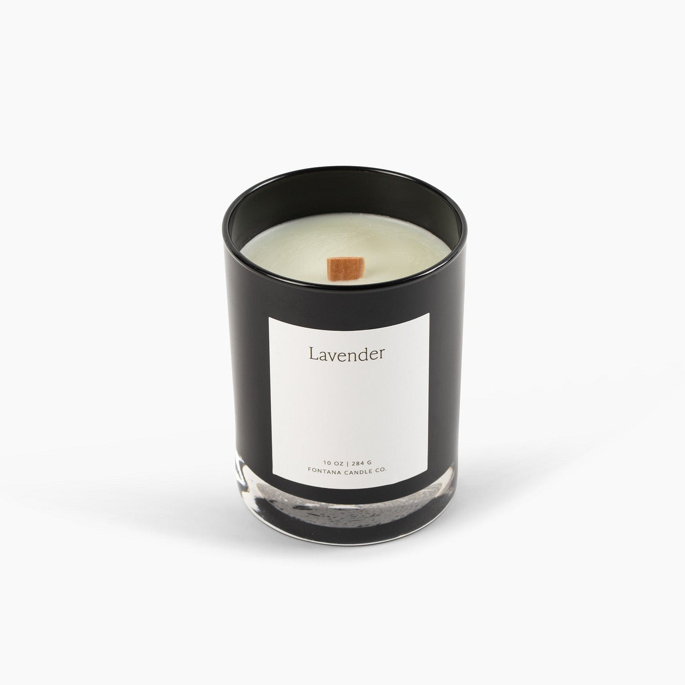 Unlit black glass candle with a white label on a white background.