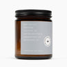 Side image of an amber glass jar candle with a light gray label and the ingredient list beeswax, coconut oil, vanilla planifolia, spearmint oil, and natural triethyl citrate.
