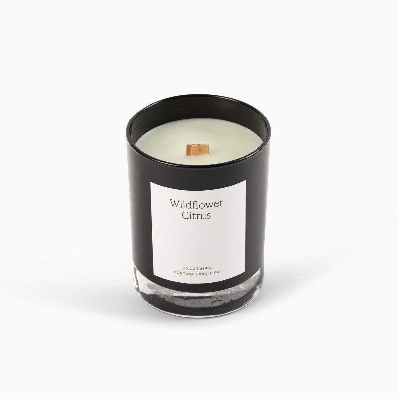 Unlit black glass candle with a wooden wick on a white background.
