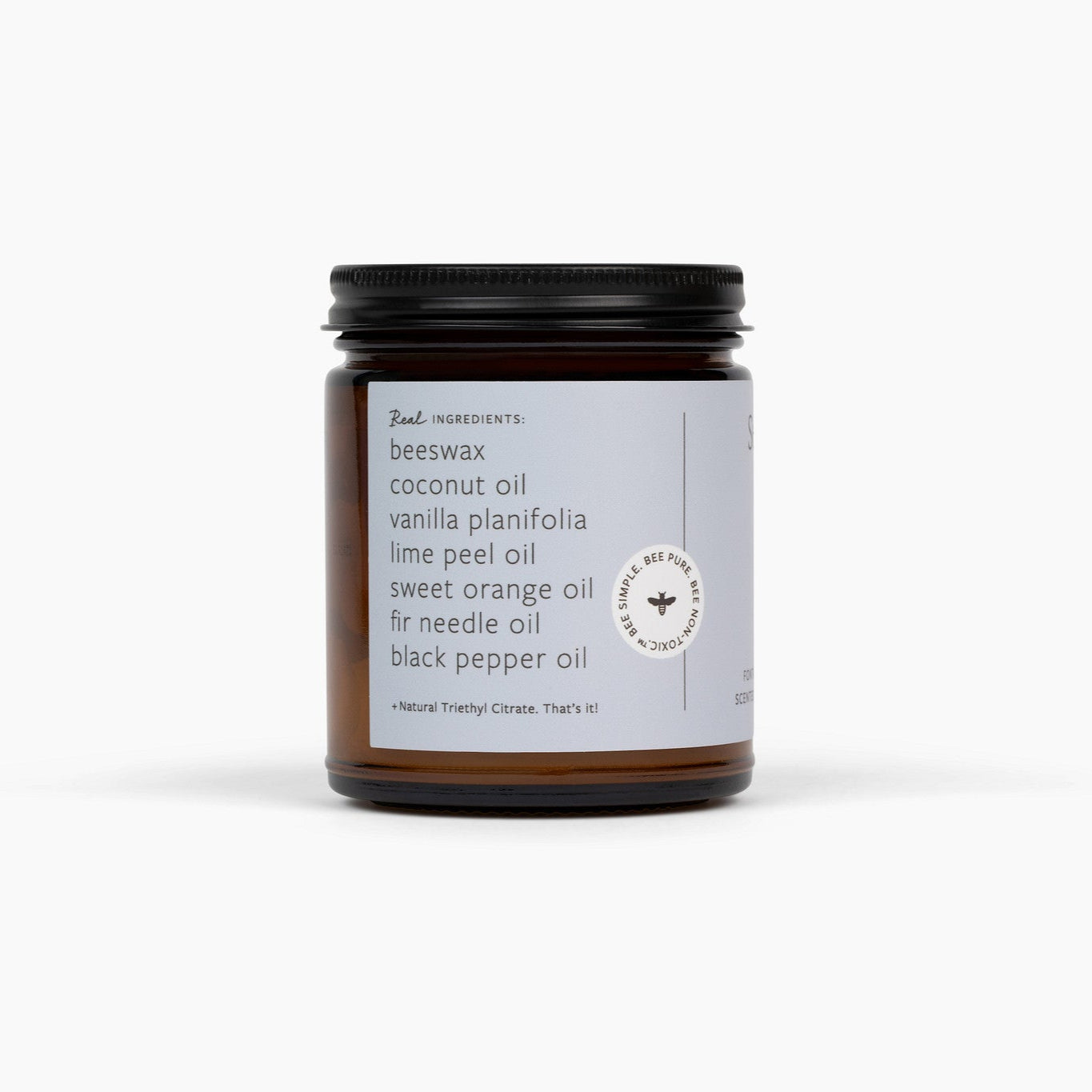 Side view of an amber glass jar candle with a black lid and light blue label. The candle is in front of a white background. 