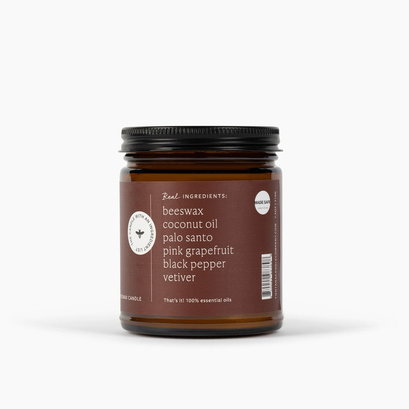 Side view of an amber glass jar of beeswax coconut oil candle with a black lid and a brown label, shown on a clean white background.
