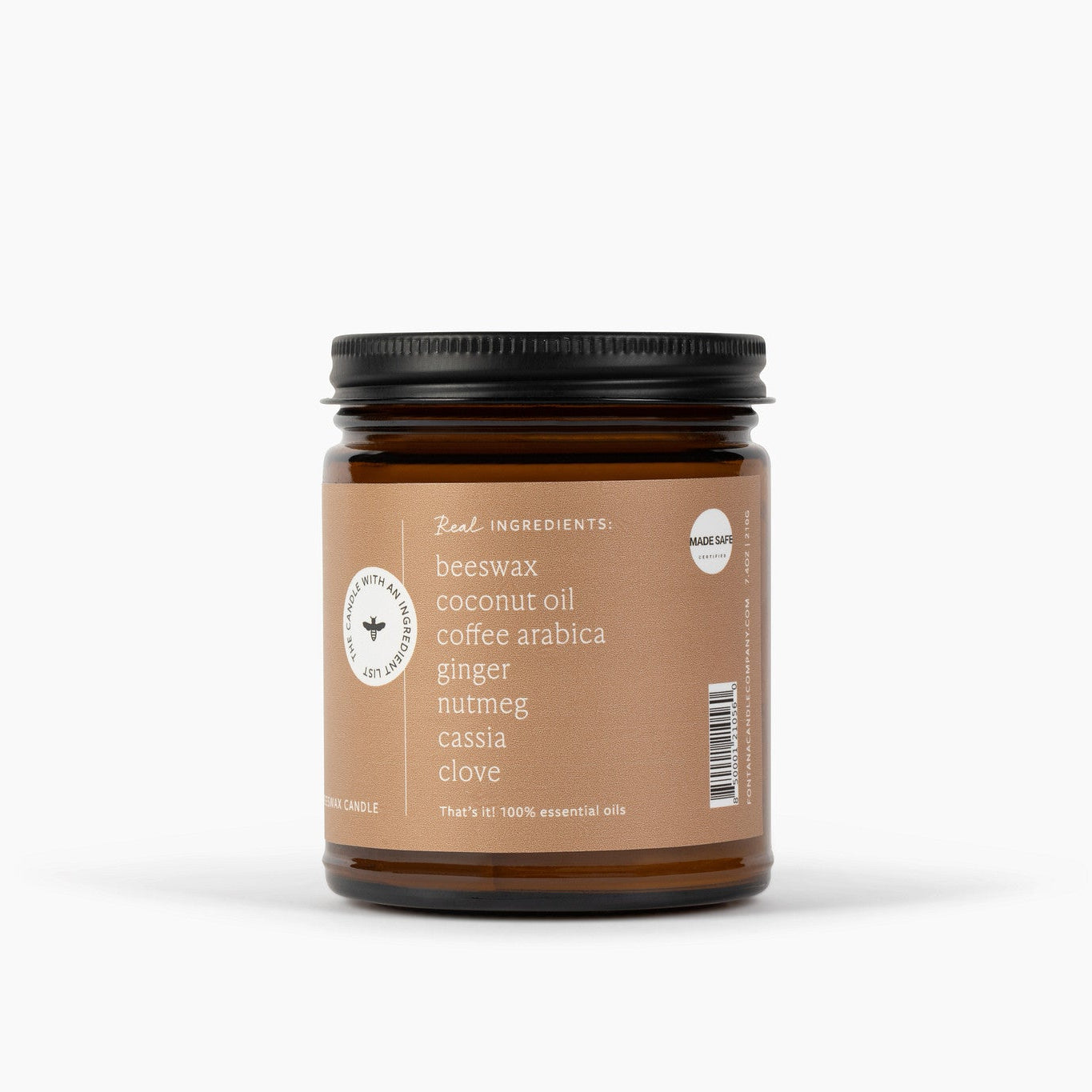 The side view of an amber glass jar candle with a black metal lid and a tan label, shown on a clean white background. The label reads 'Beeswax, Coconut Oil, Coffee Arabica, Ginger, Nutmeg, Cassia, clove'.