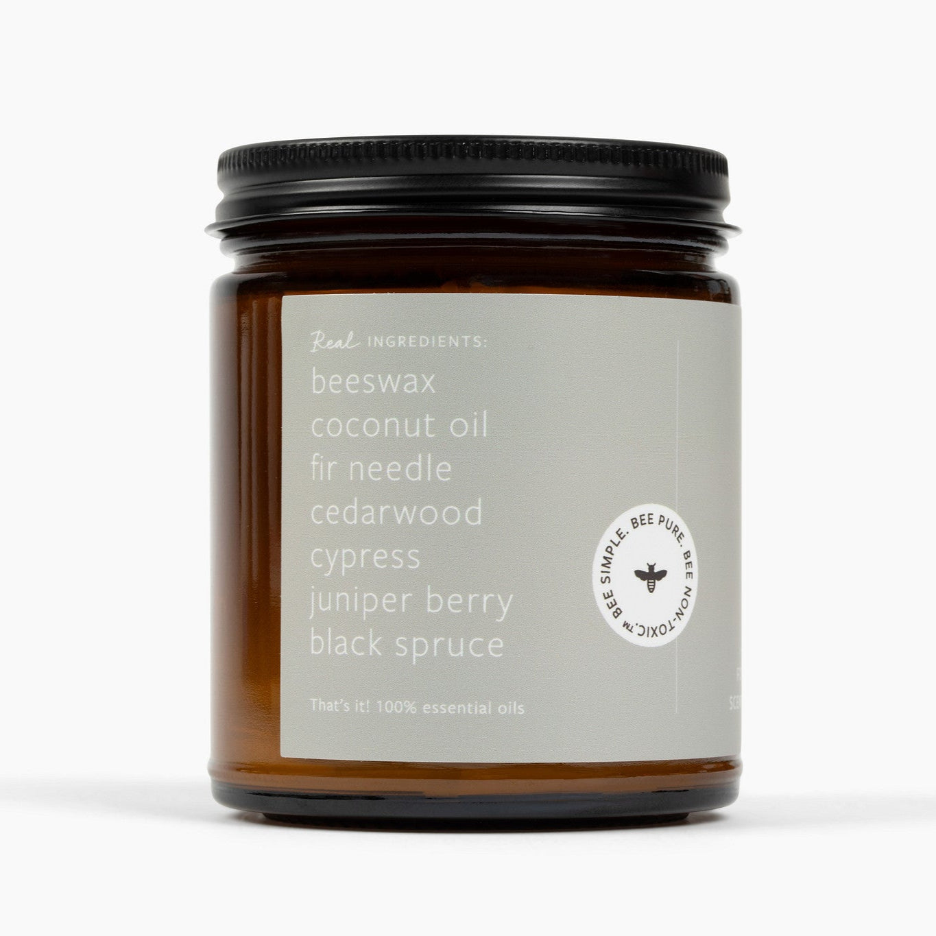 Side of an amber glass jar candle that shows the ingredients: beeswax, coconut oil, fir needle, cedarwood, cypress, juniper berry, and black spruce.