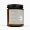 Side of an amber glass jar candle that shows the ingredients: beeswax, coconut oil, fir needle, cedarwood, cypress, juniper berry, and black spruce.