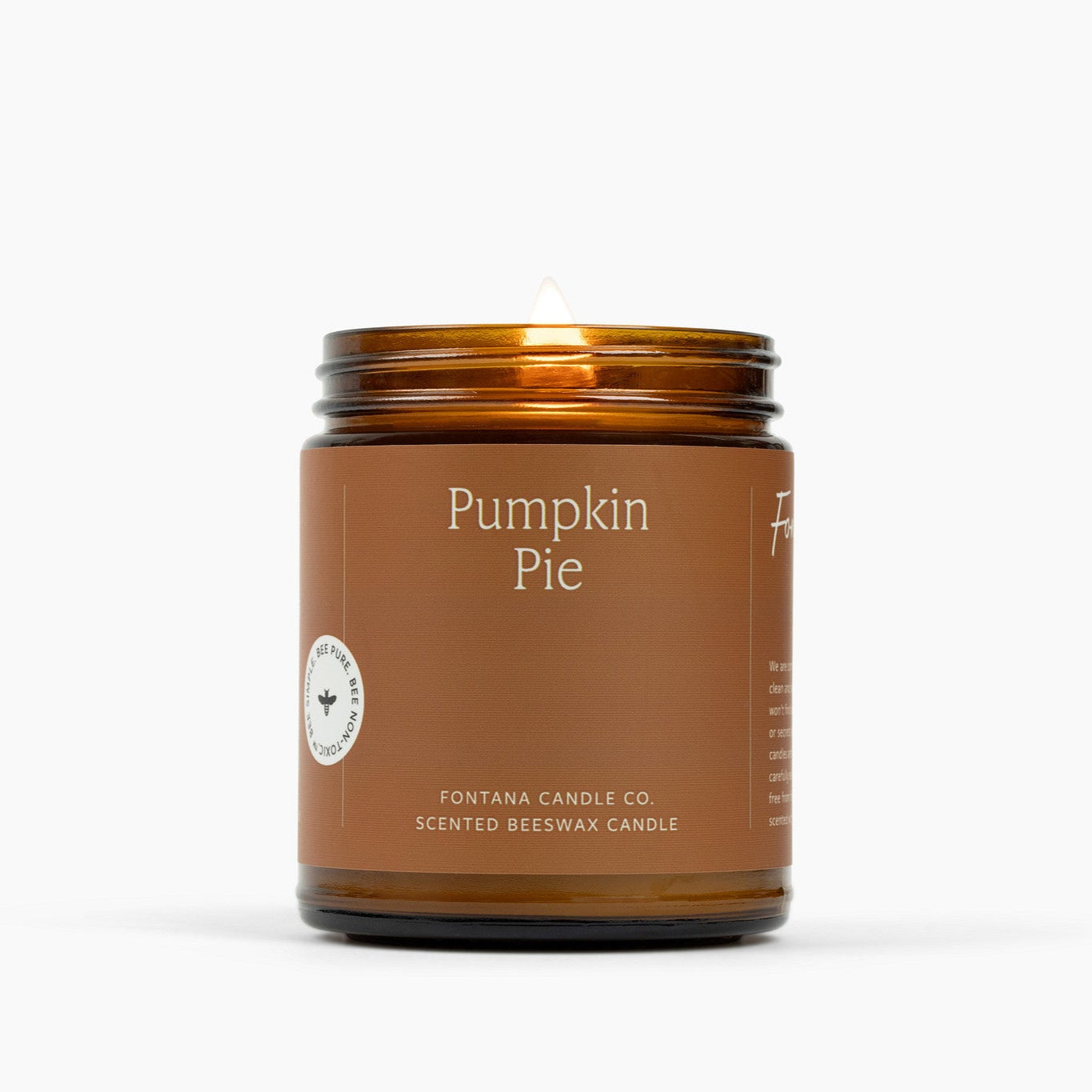 Lit amber glass jar candle with brown label and Pumpkin Pie scent.