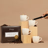 Fontana Coffee Shop packaging with 4 lit coffee cup candles and coffee beans on a beige background