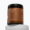 Amber glass jar candle with Pumpkin Pie on a deep orange label, in front of a white background.