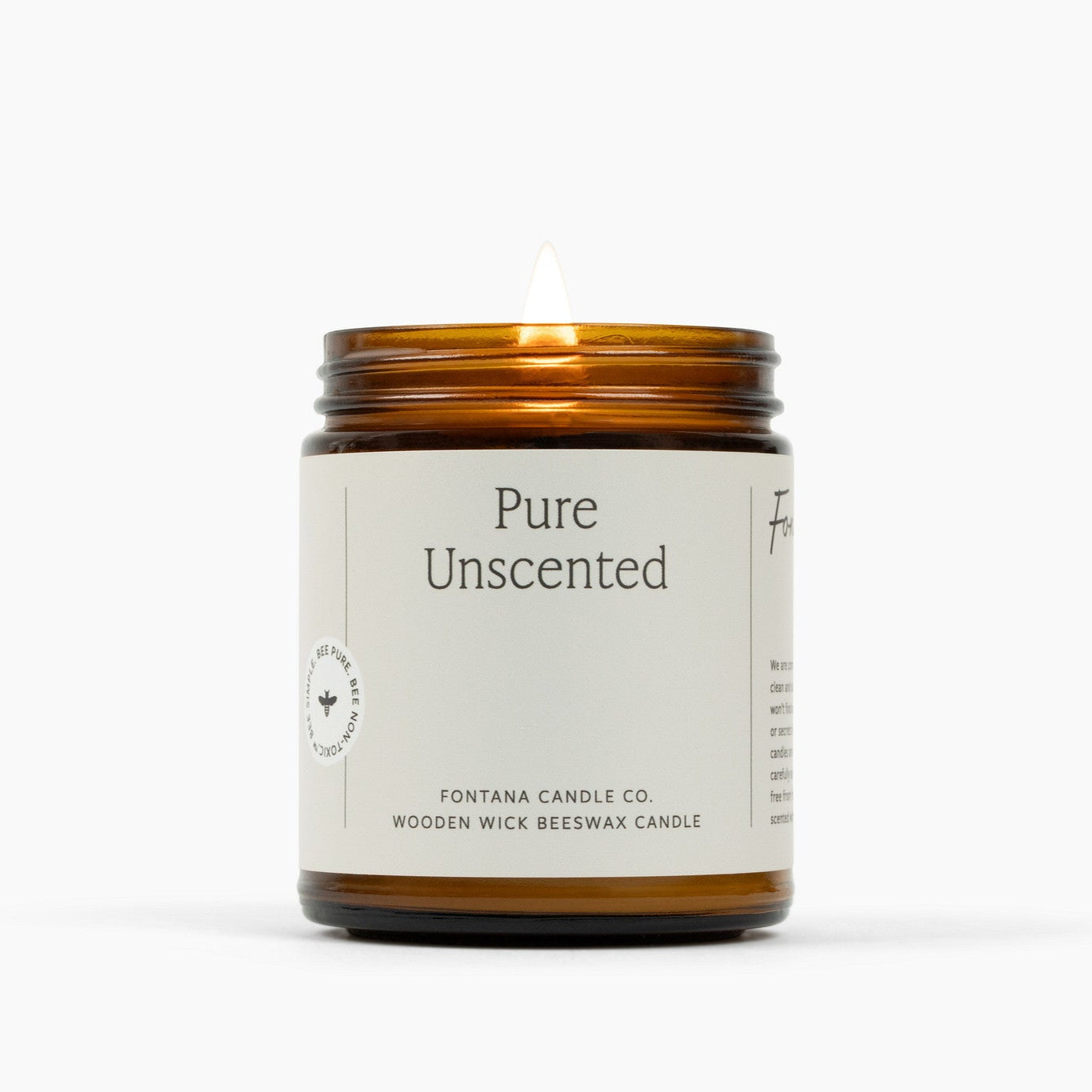 Lit amber glass jar candle with a white label for Pure Unscented. 