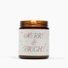 Lit amber glass jar candle with a cream colored label and festive holiday text in red green and purple: Merry & Bright.