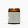 Lit amber glass jar candle with a light gray label for the scent Cozy Cabin.