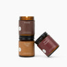 Three amber glass jar candles on a white background: Fireside, Autumn Trail, and Warm Flannel.