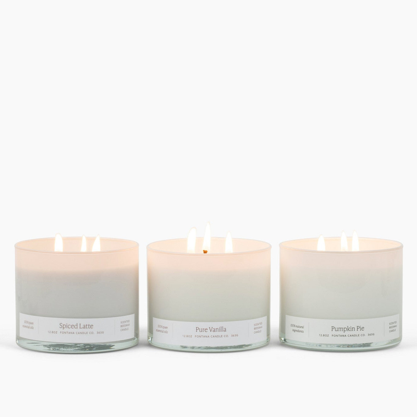 3 Lit 3-Wick candles in white glass vessels: Spiced Latte, Pure Vanilla, and Pumpkin Pie. 
