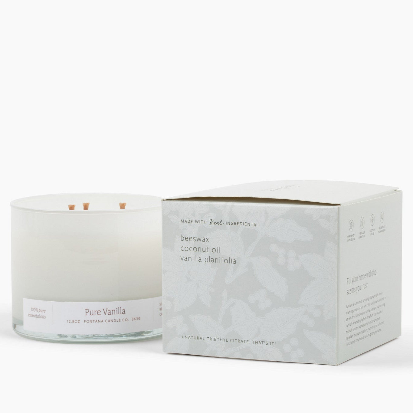 Unlit 3 wick candle in a white glass vessel with a white box to the right of it with the ingredients listed: beeswax, coconut oil, vanilla planifolia and natural triethyl citrate. 