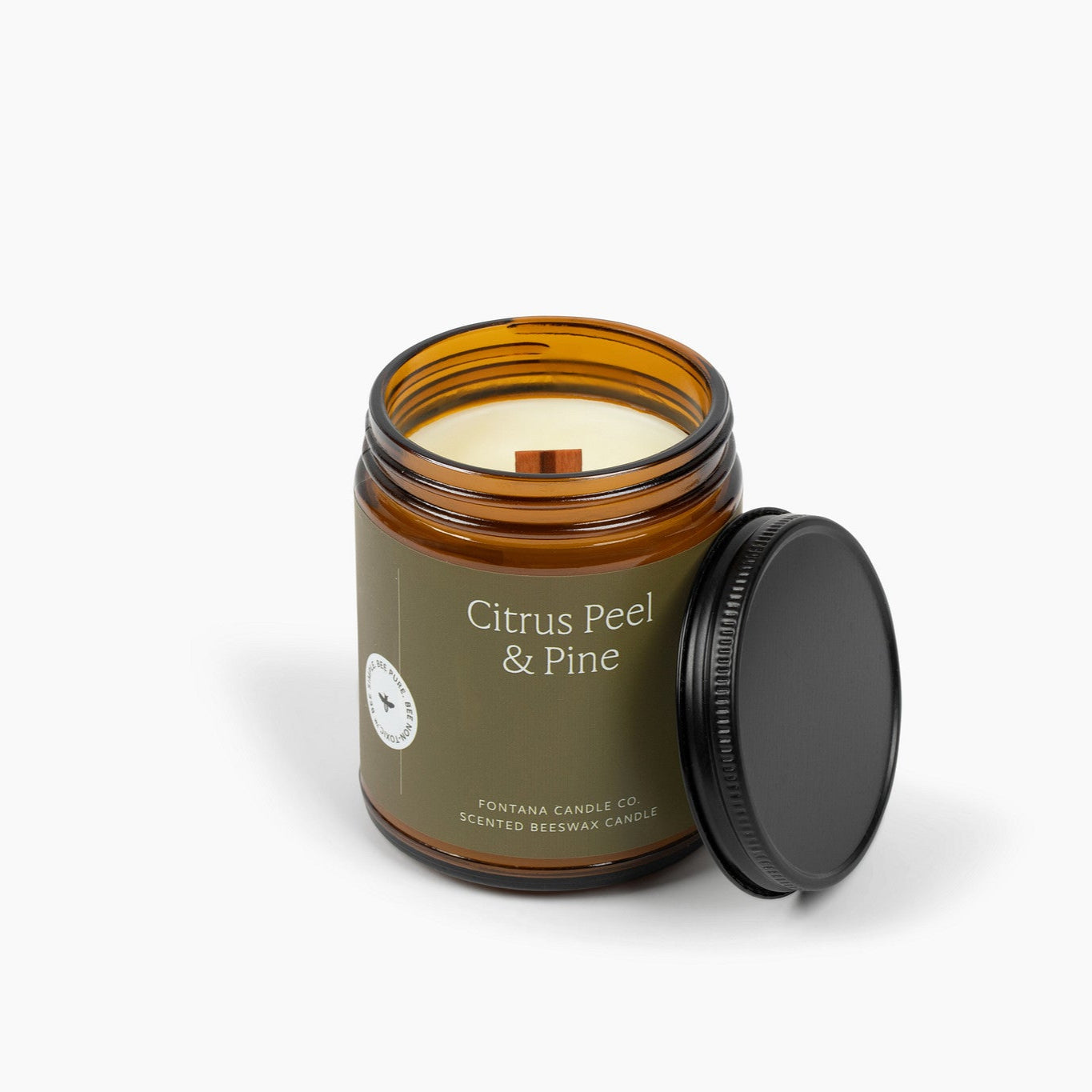 Amber glass jar candle with a military green label and a wooden wick. 